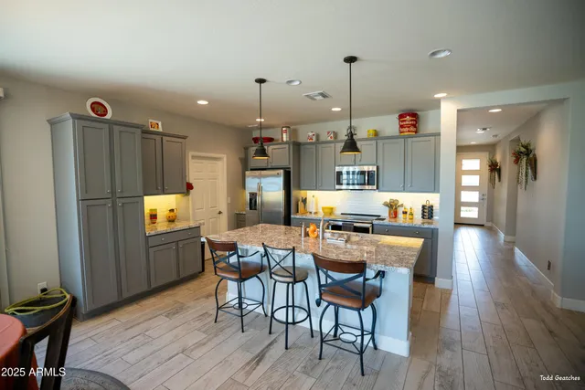 a kitchen with a sink a stove and lots of wooden cabinets