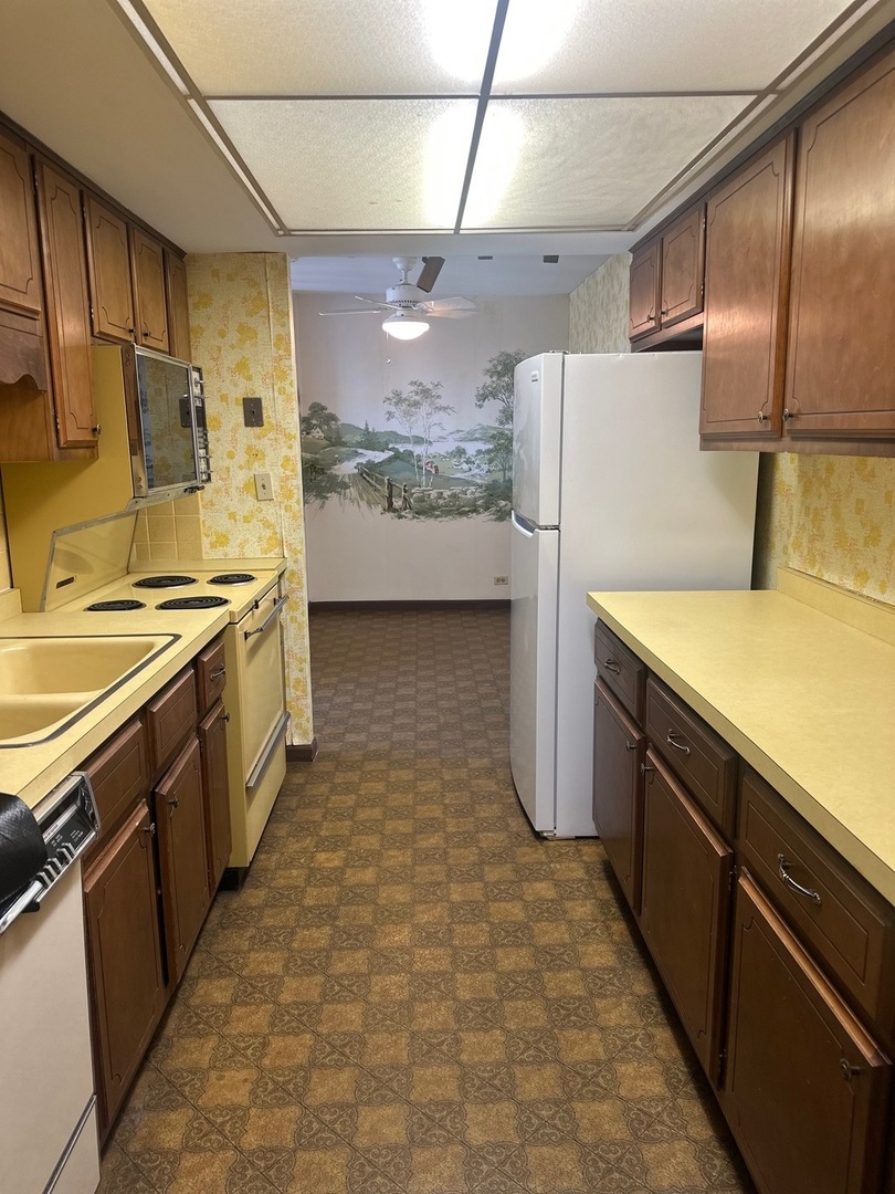 101 Bar Harbour Road, Unit 6D Schaumburg, IL 60193 - Photo 6 of 14 a kitchen with stainless steel appliances a refrigerator a sink and wooden cabinets