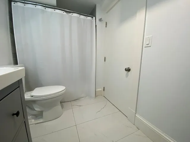 a bathroom with a toilet and a shower