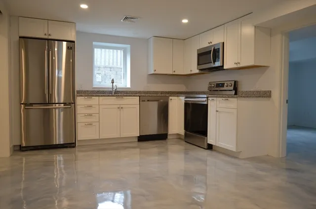 a kitchen with stainless steel appliances granite countertop a refrigerator sink and microwave