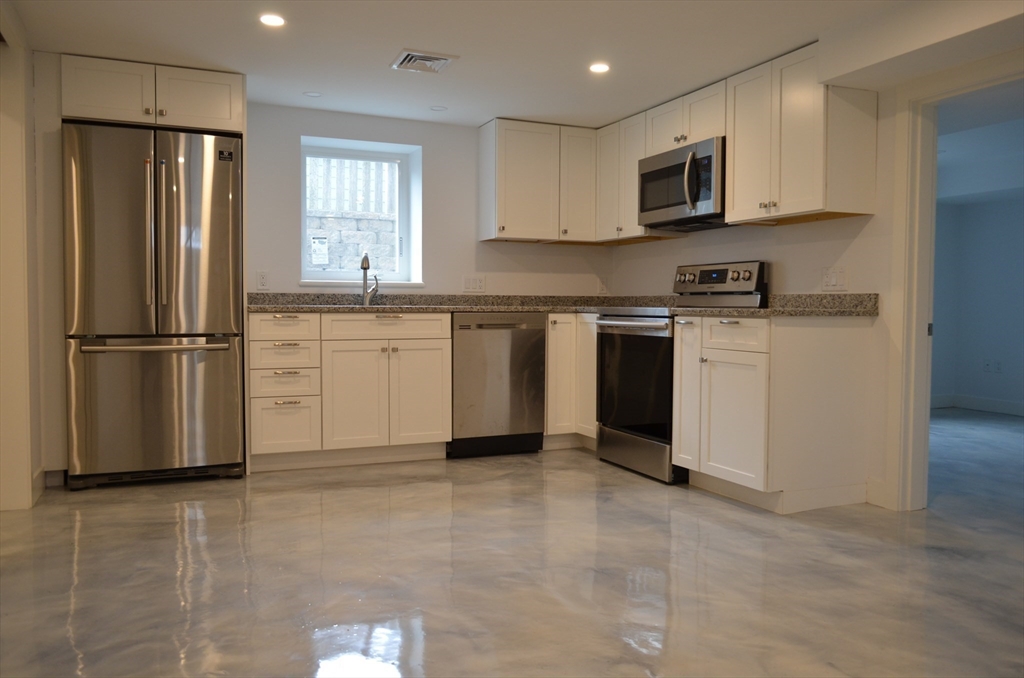 10 Gloucester Avenue, Unit B Gloucester, MA 01930 - Photo 5 of 13 a kitchen with stainless steel appliances granite countertop a refrigerator sink and microwave