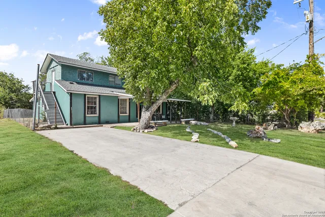 a view of a house with backyard and a tree