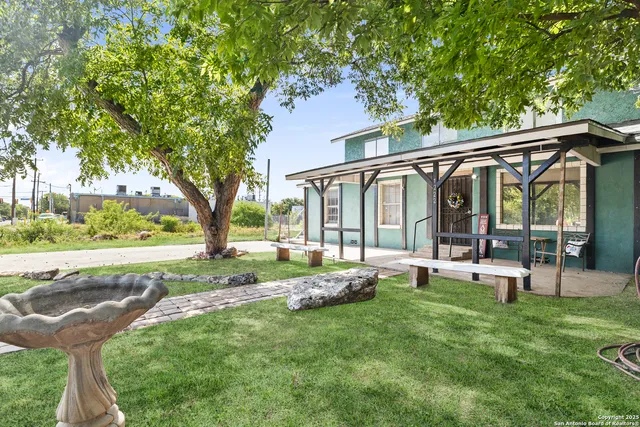 a view of a house with backyard and sitting area