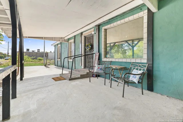 a view of an empty room with wooden floor and furniture