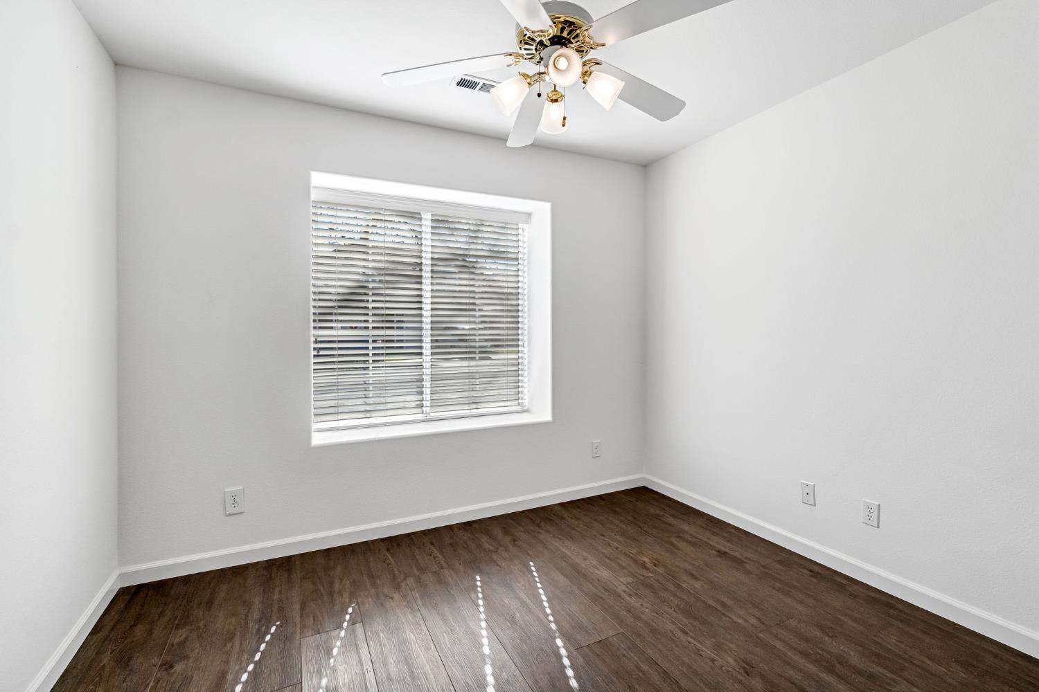 265 West Decatur Avenue Clovis, CA 93611 - Photo 11 of 19 an empty room with wooden floor fan and windows