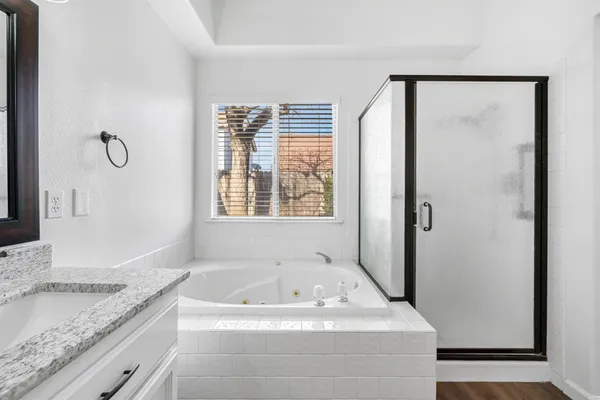 a bathroom with bathtub and a granite counter tops