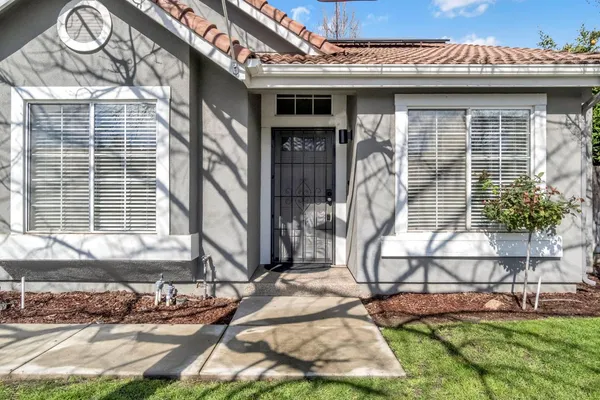 a view of a house with a patio and a yard