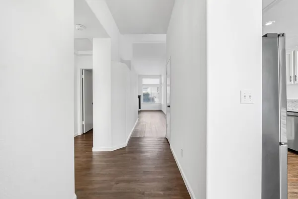 a view of a hallway with wooden floor
