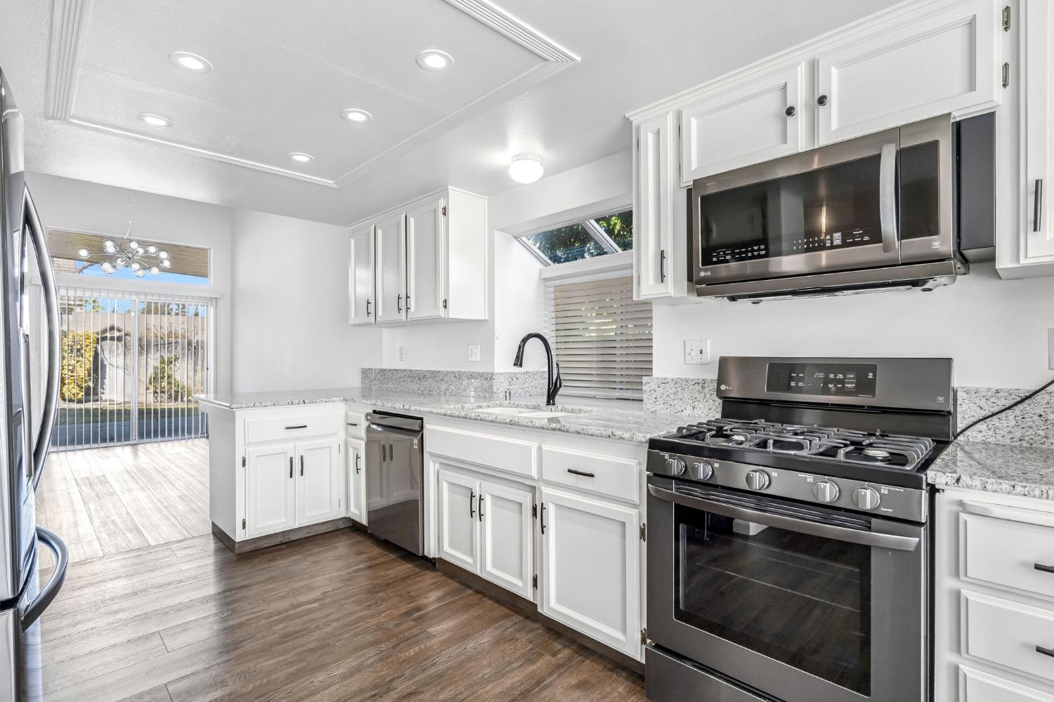 265 West Decatur Avenue Clovis, CA 93611 - Photo 6 of 19 a kitchen with stainless steel appliances white cabinets a stove top oven and sink