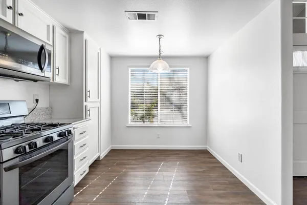 a kitchen with a stove a microwave and window