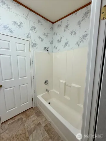 a white bath tub sitting next to a shower curtain