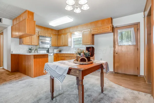 a room with stainless steel appliances kitchen island granite countertop furniture and a window