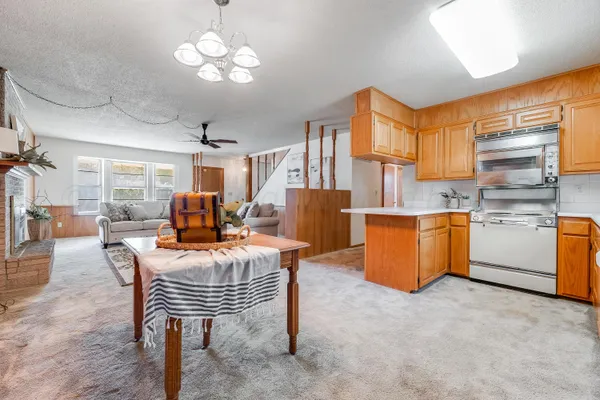 a living room with furniture a chandelier and a dining table
