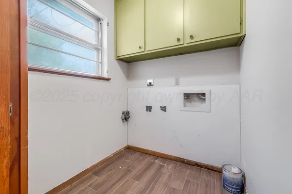 a view of a small space with wooden floor and cabinets
