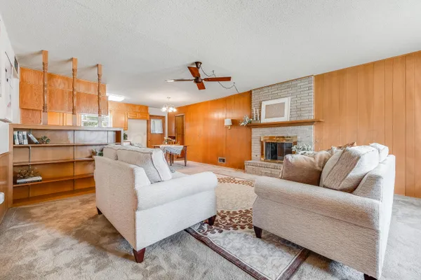 a living room with furniture kitchen view and a large window