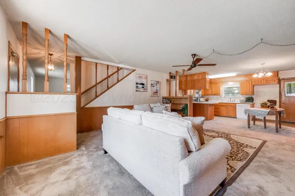 a living room with furniture and a view of kitchen