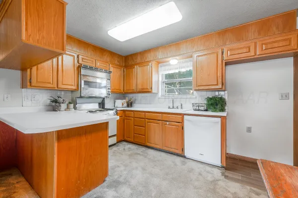 a kitchen with stainless steel appliances granite countertop a sink a stove and a refrigerator