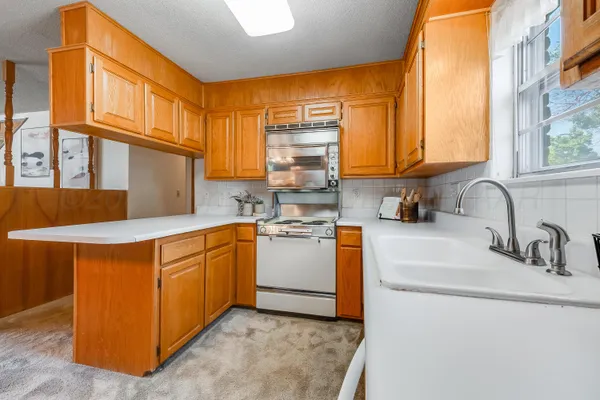 a kitchen with stainless steel appliances granite countertop a sink a stove and a refrigerator