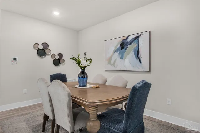 a dining room with furniture and wooden floor