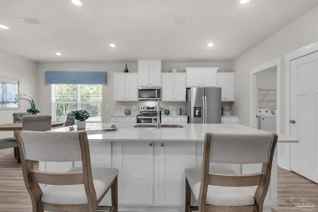 a kitchen with stainless steel appliances granite countertop a table and chairs