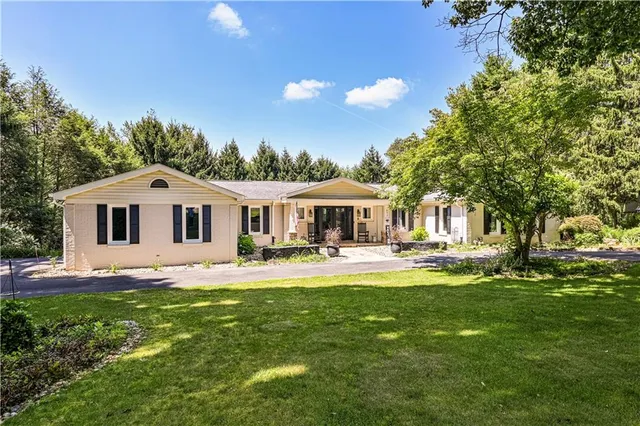 a front view of a house with swimming pool having outdoor seating
