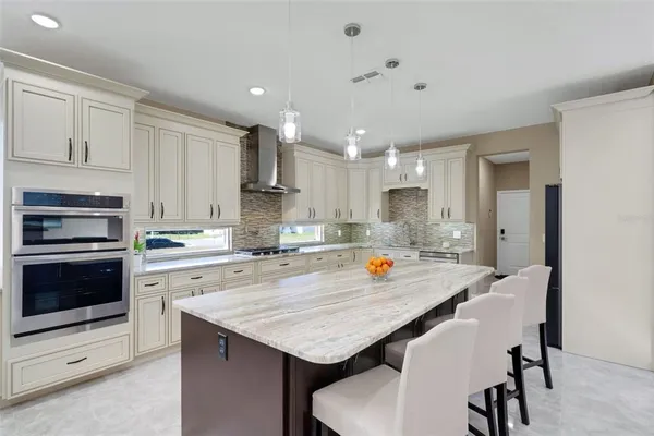 a kitchen with a dining table chairs refrigerator and cabinets
