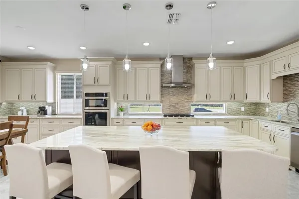 a dining room with stainless steel appliances kitchen island a table and chairs