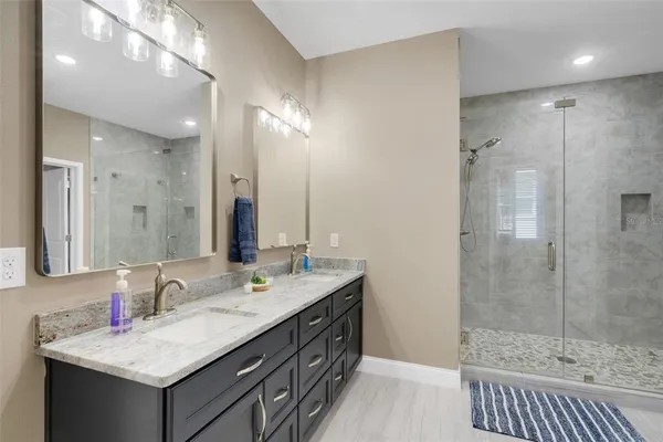 a bathroom with a granite countertop sink a toilet a mirror and bathtub