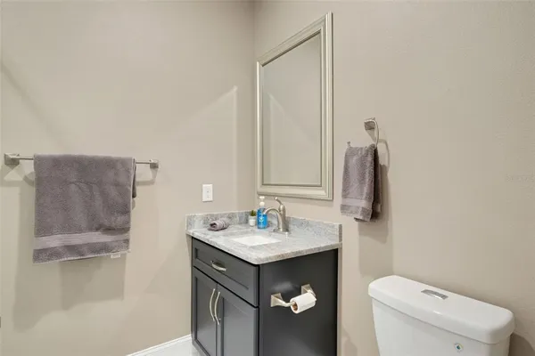 a bathroom with a granite countertop sink toilet a mirror and shower