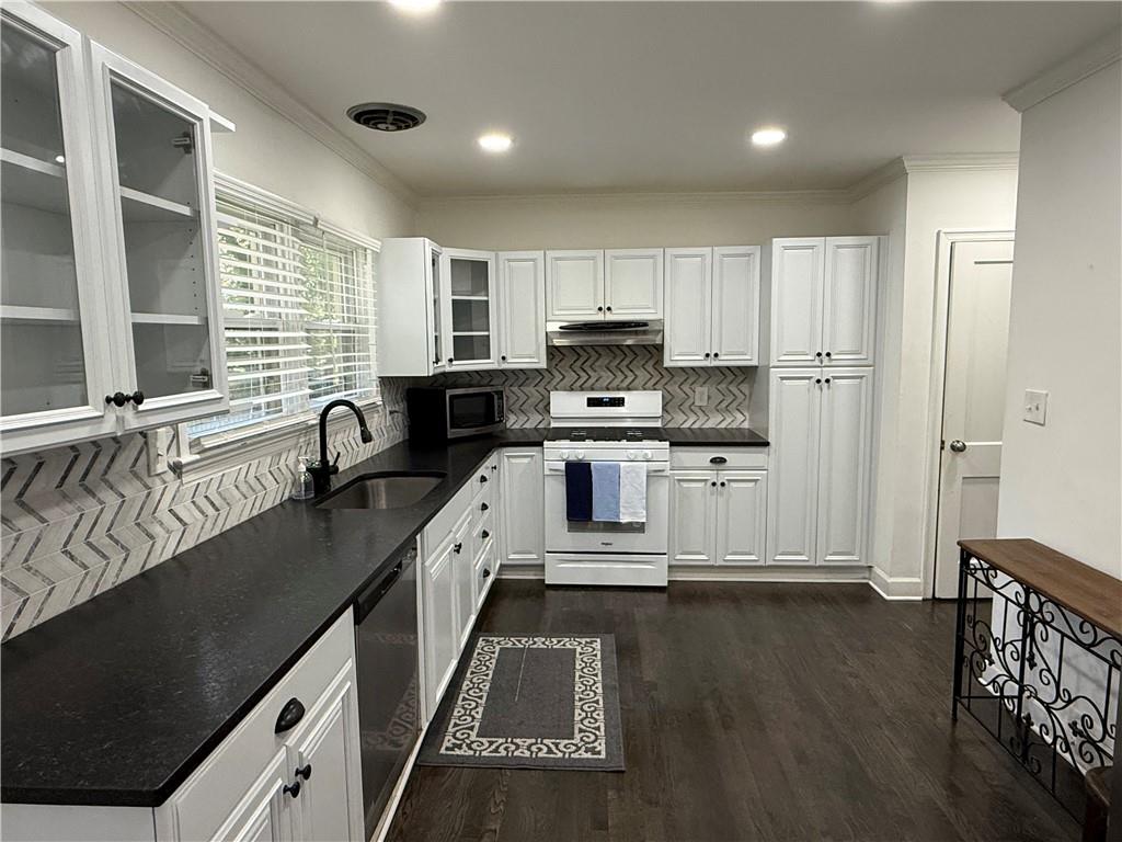 1140 Goodwin Place Northeast, Unit 4 Atlanta, GA 30319 - Photo 11 of 50 a kitchen with kitchen island granite countertop a sink appliances cabinets and a counter top space