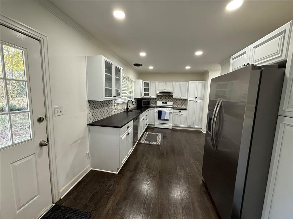 1140 Goodwin Place Northeast, Unit 4 Atlanta, GA 30319 - Photo 9 of 50 a kitchen with stainless steel appliances granite countertop a refrigerator a sink a stove and white cabinets with wooden floor