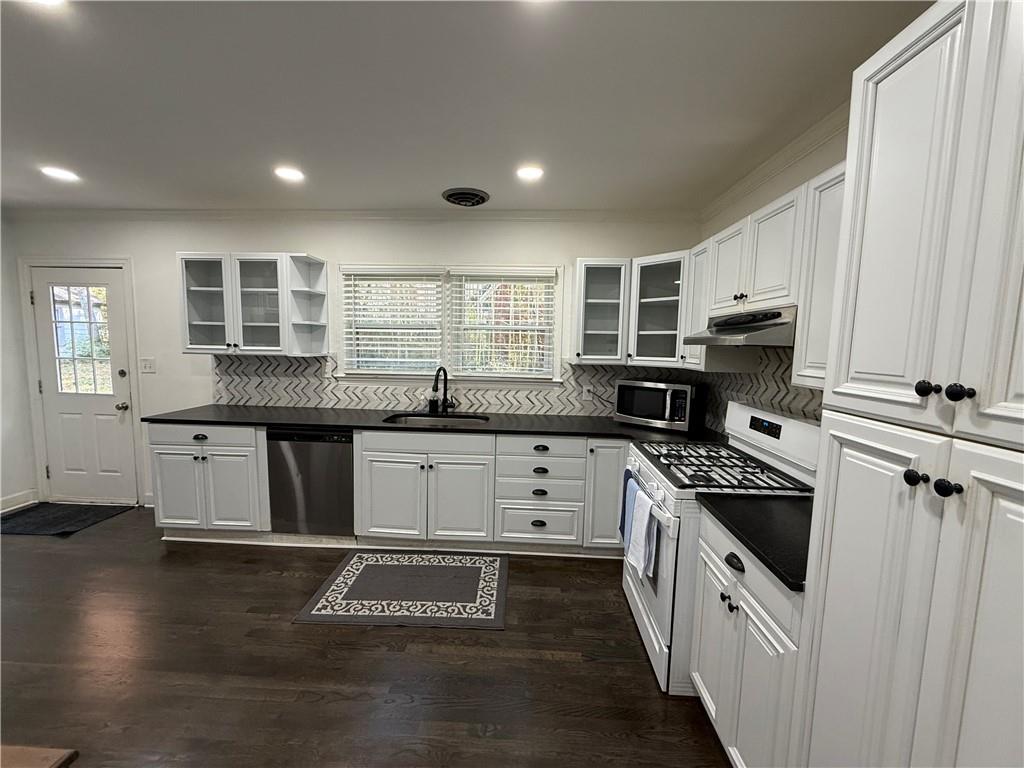 1140 Goodwin Place Northeast, Unit 4 Atlanta, GA 30319 - Photo 10 of 50 a kitchen with stainless steel appliances granite countertop a stove a sink and a refrigerator