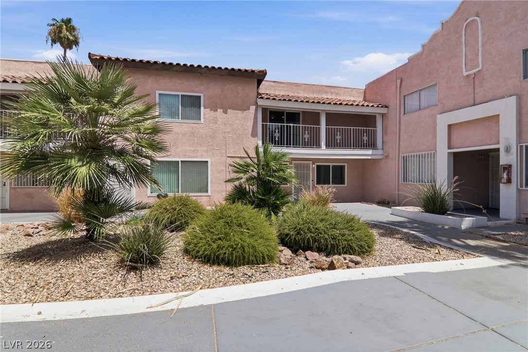 Mature palms and desert landscaping adorn the exterior of this multi-level residential building, offering a welcoming facade.