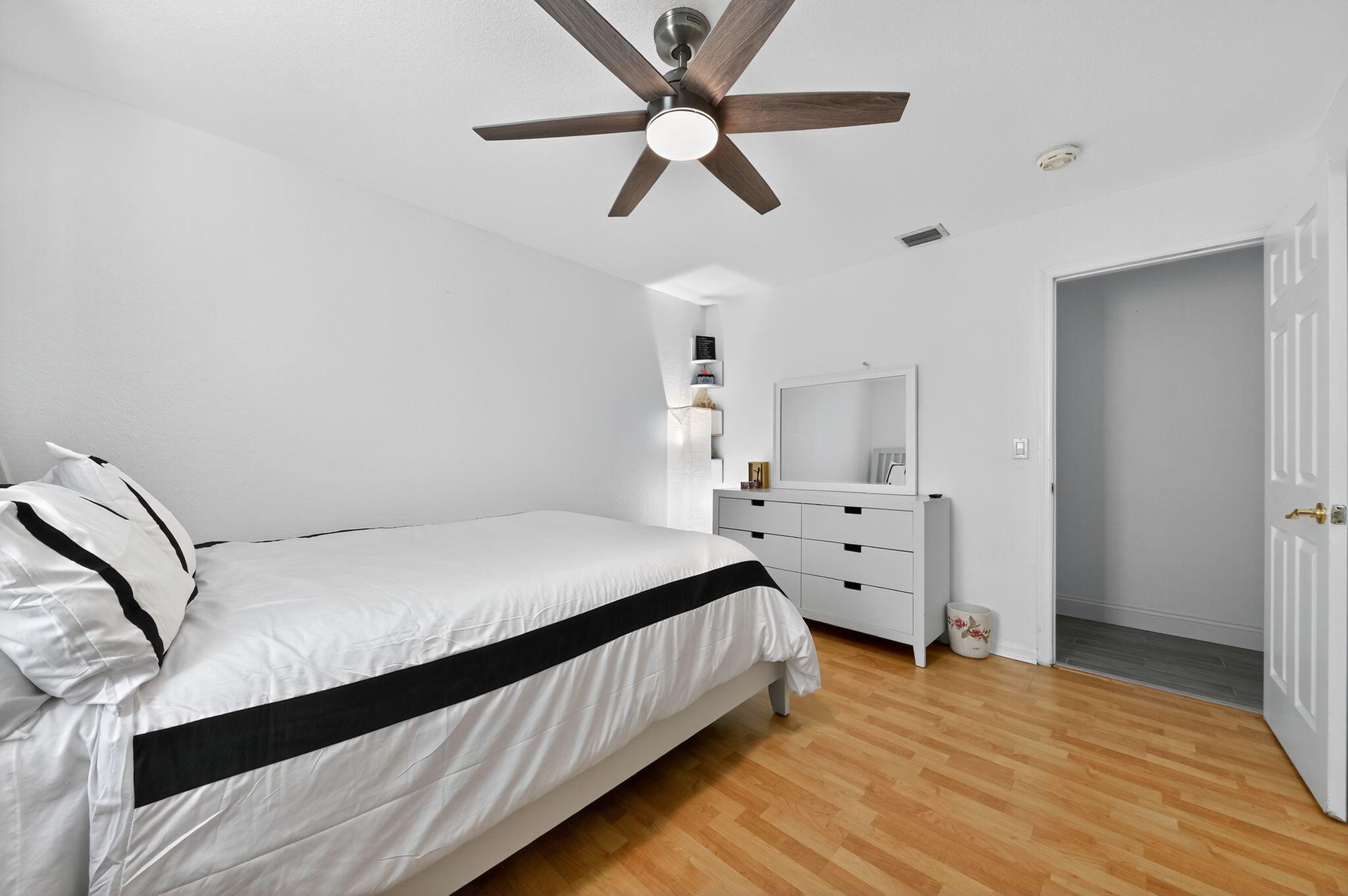 407 Highwood Circle Jupiter, FL 33458 - Photo 17 of 30 a bedroom with a large bed and a ceiling fan