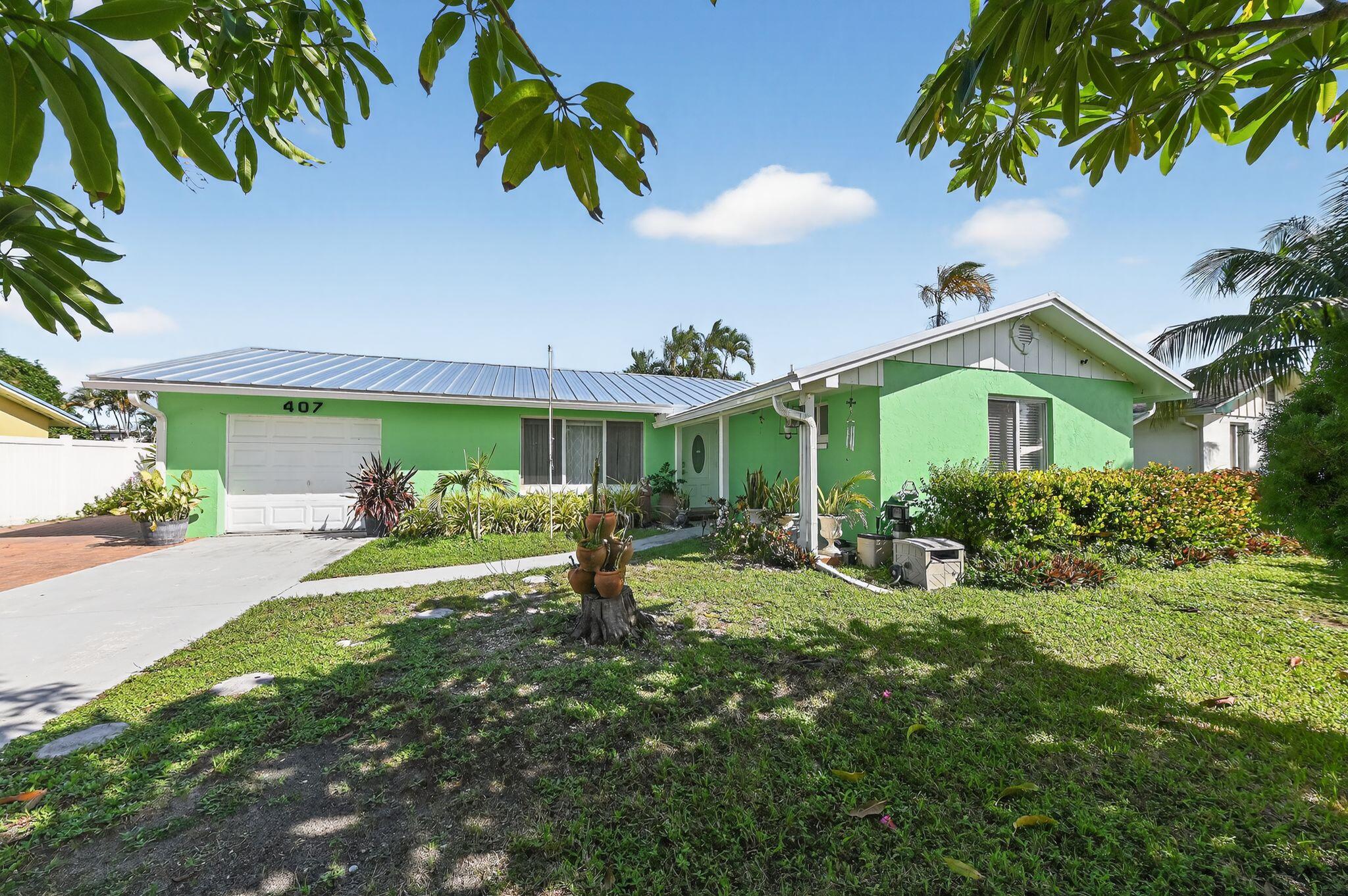 407 Highwood Circle Jupiter, FL 33458 - Photo 2 of 30 a front view of a house with garden