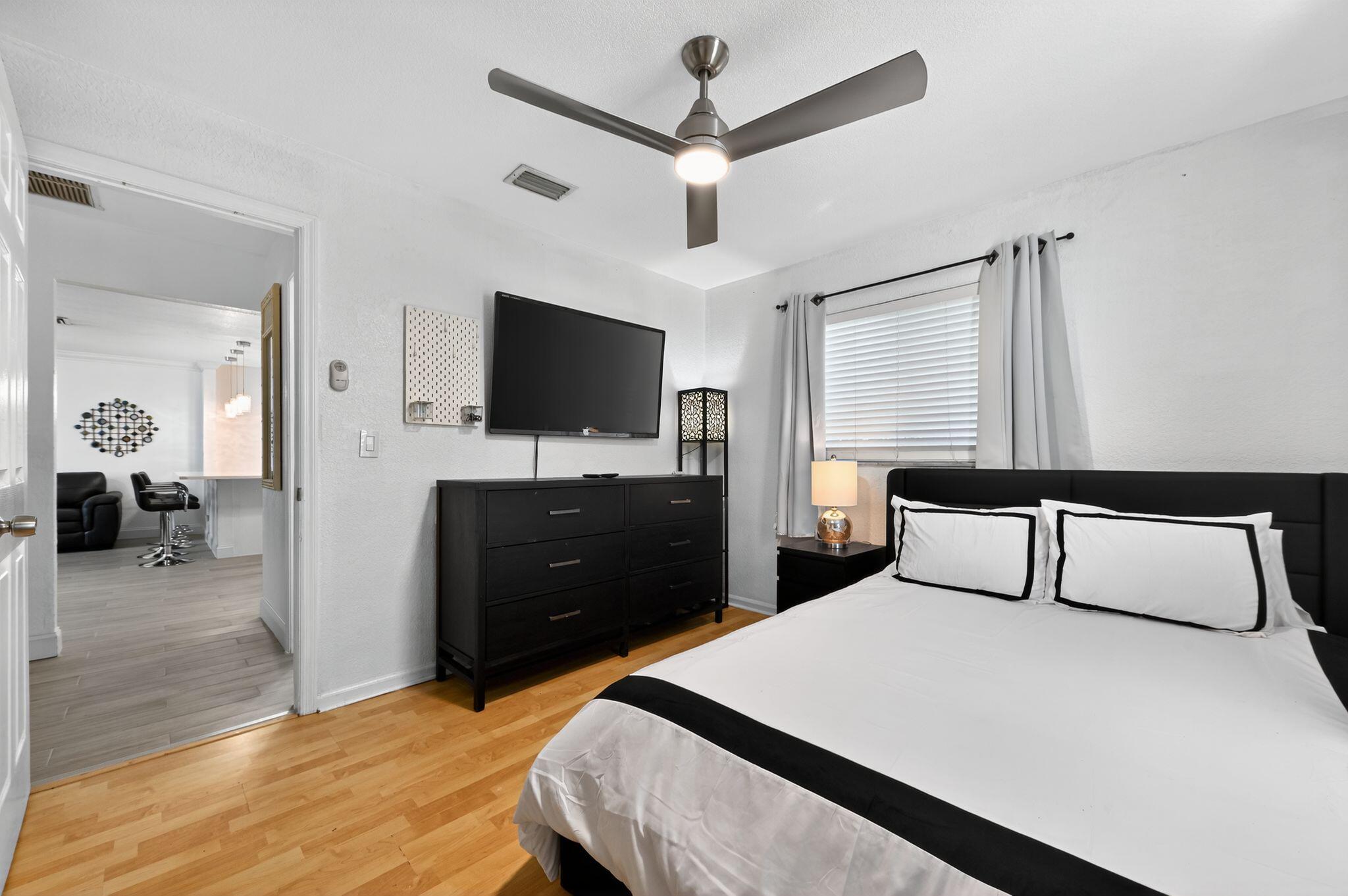 407 Highwood Circle Jupiter, FL 33458 - Photo 23 of 30 a bedroom with a bed and a flat tv screen on wall