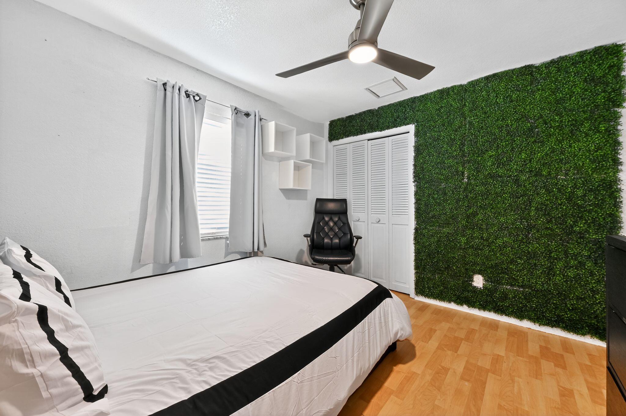 407 Highwood Circle Jupiter, FL 33458 - Photo 24 of 30 a bedroom with a bed and a chandelier