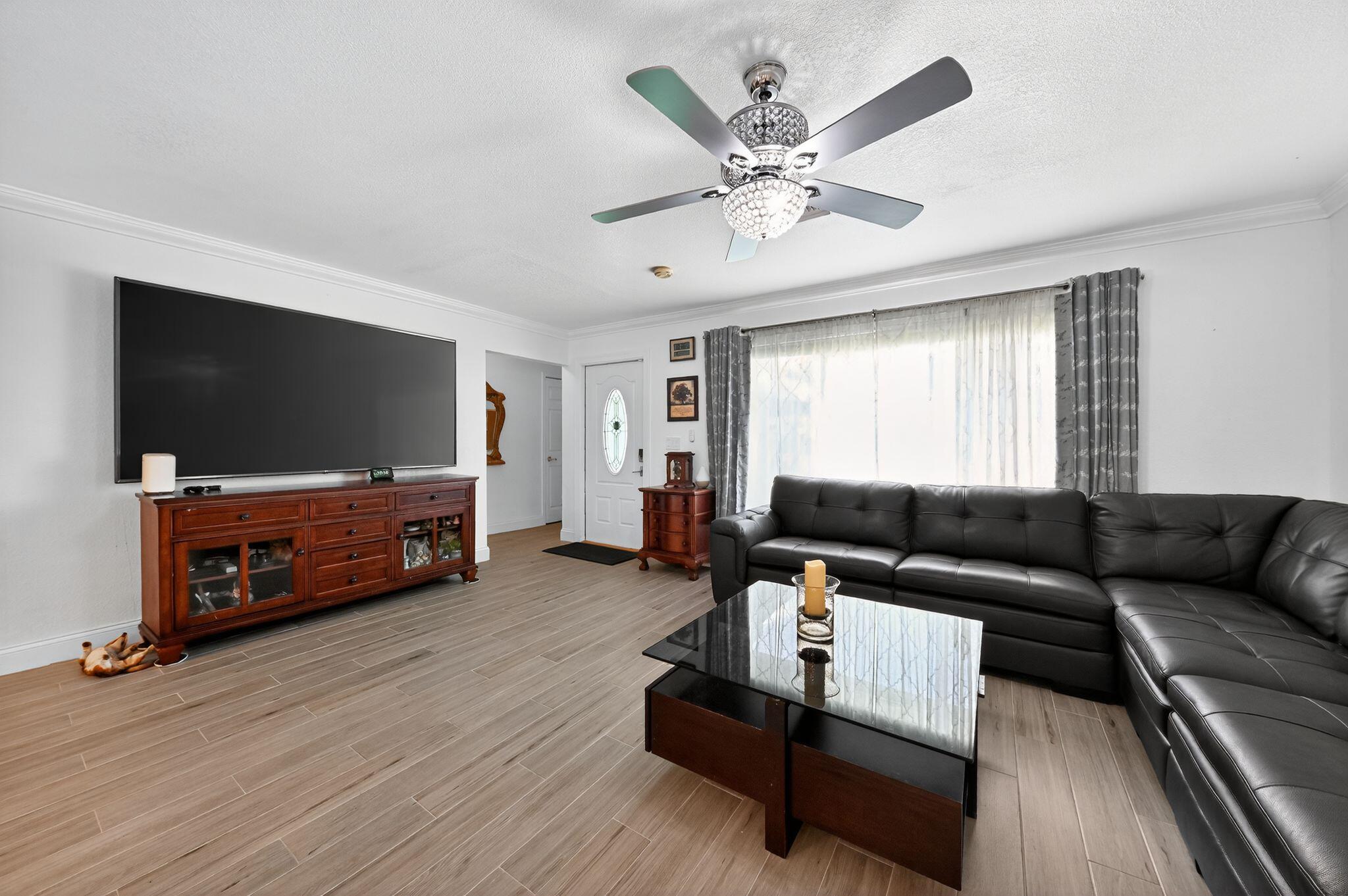 407 Highwood Circle Jupiter, FL 33458 - Photo 5 of 30 a living room with furniture and a flat screen tv
