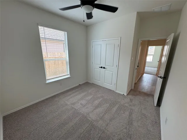 an empty room with windows and fan