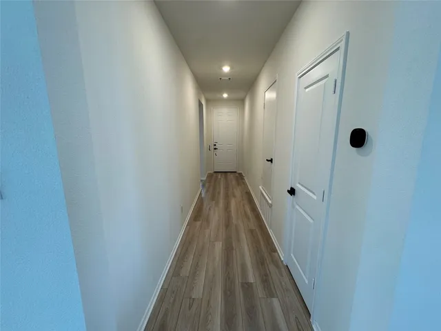 a view of a hallway with wooden floor