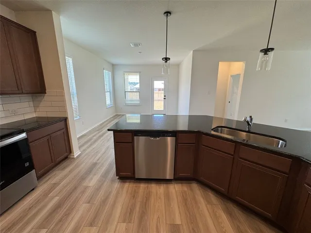 a kitchen with a sink a window and cabinets