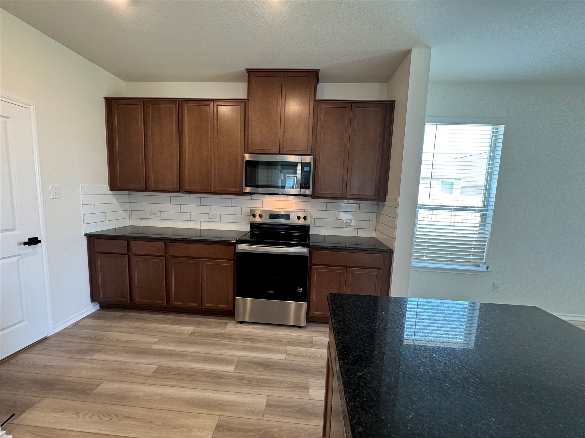 216 Coastal Way Georgetown, TX 78628 - Photo 17 of 38 a kitchen with granite countertop stainless steel appliances and wooden cabinets