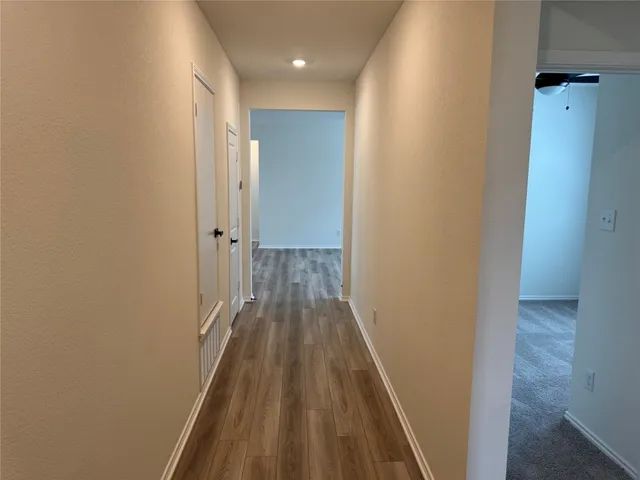 a view of a hallway with wooden floor