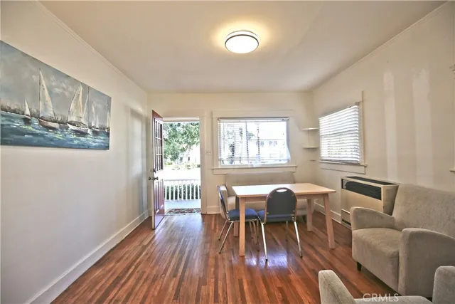 a view of a dining room with furniture a chandelier and wooden floor