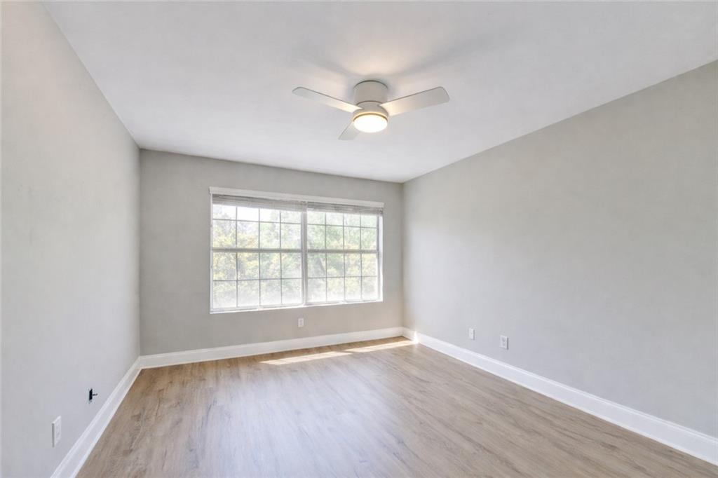 6980 Roswell Road, Unit C5 Atlanta, GA 30328 - Photo 13 of 22 a view of an empty room with wooden floor and a window