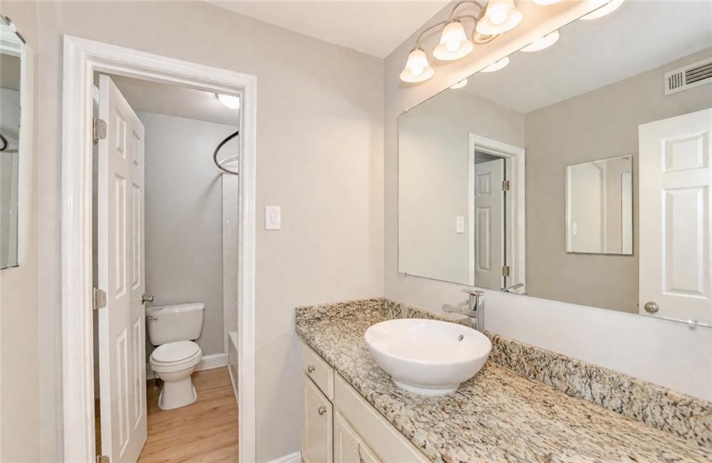 6980 Roswell Road, Unit C5 Atlanta, GA 30328 - Photo 14 of 22 a bathroom with a granite countertop sink toilet and shower curtains