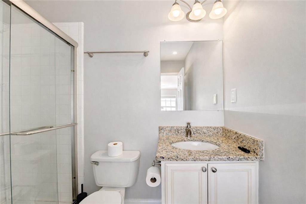 6980 Roswell Road, Unit C5 Atlanta, GA 30328 - Photo 16 of 22 a bathroom with a granite countertop sink a mirror and a toilet