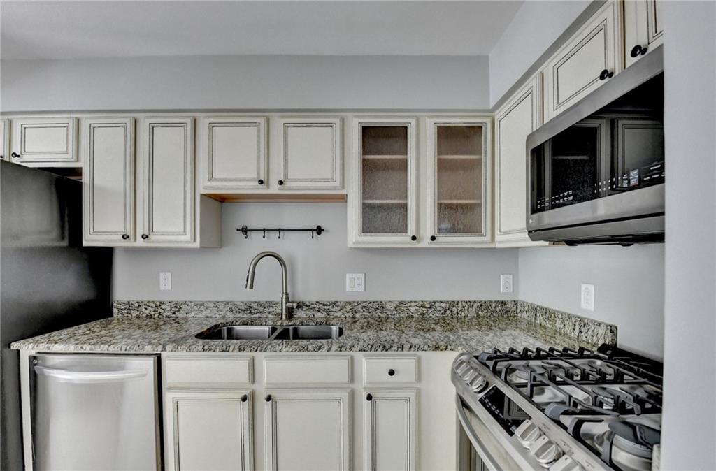 6980 Roswell Road, Unit C5 Atlanta, GA 30328 - Photo 7 of 22 a kitchen with granite countertop a stove and a sink