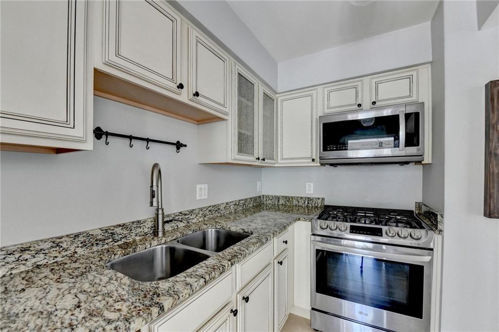 6980 Roswell Road, Unit C5 Atlanta, GA 30328 - Photo 9 of 22 a kitchen with granite countertop a sink stainless steel appliances and cabinets