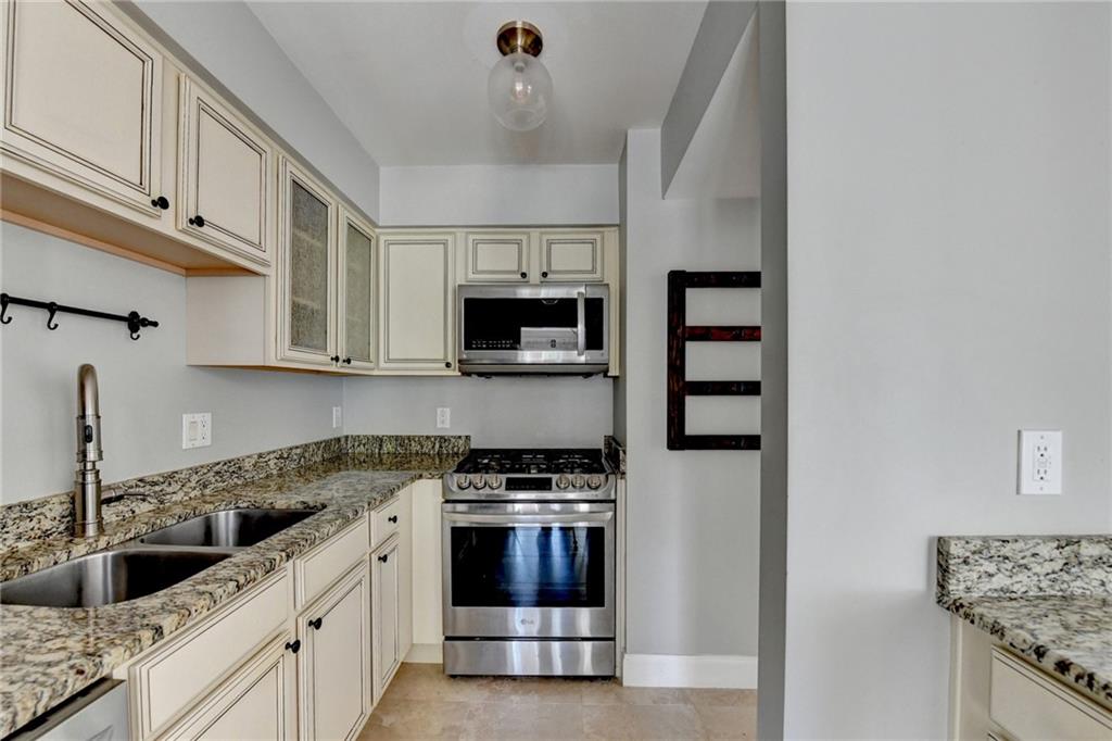 6980 Roswell Road, Unit C5 Atlanta, GA 30328 - Photo 10 of 22 a kitchen with stainless steel appliances granite countertop a sink and a stove